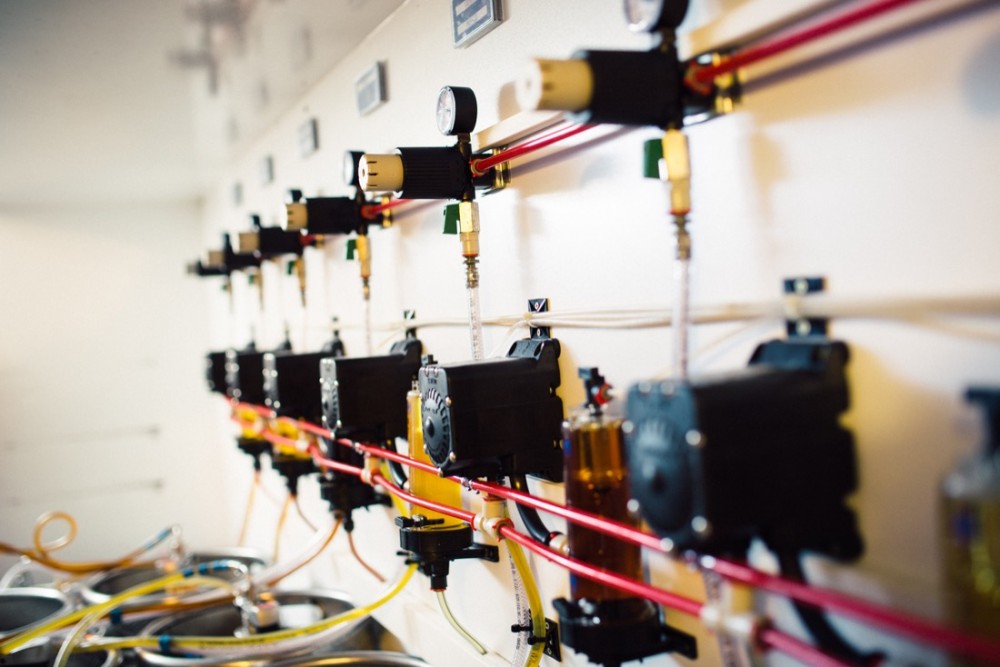 Eine Wand voller mechanischer Vorrichtungen mit vielen Kabeln und Rohren.