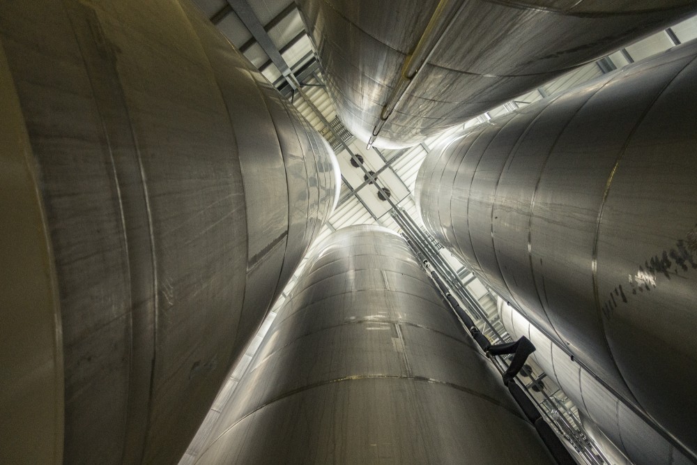 Blick nach oben in eine Halle mit vielen vertikalen großen Metallzylindern.