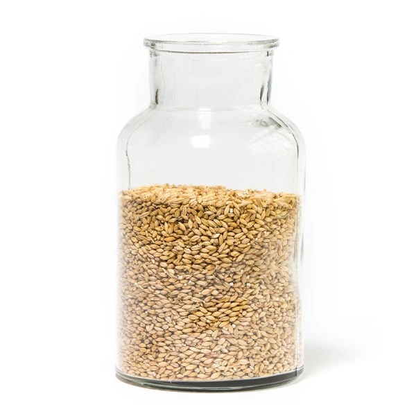 Eine Glasflasche ist teilweise mit hellbraunen Körnern gefüllt.