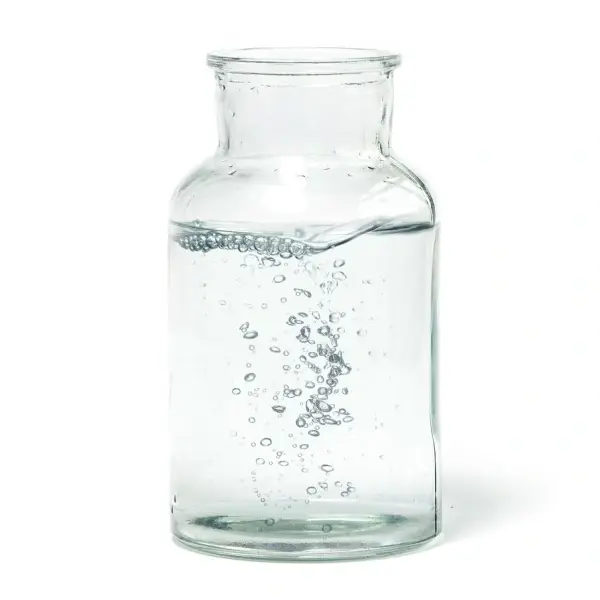 Eine durchsichtige Glasflasche ist teilweise mit Wasser gefüllt und Blasen steigen auf.