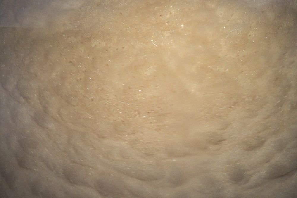 Nahaufnahme von sprudelndem Wasser, das viele kleine Blasen und Wirbel zeigt.