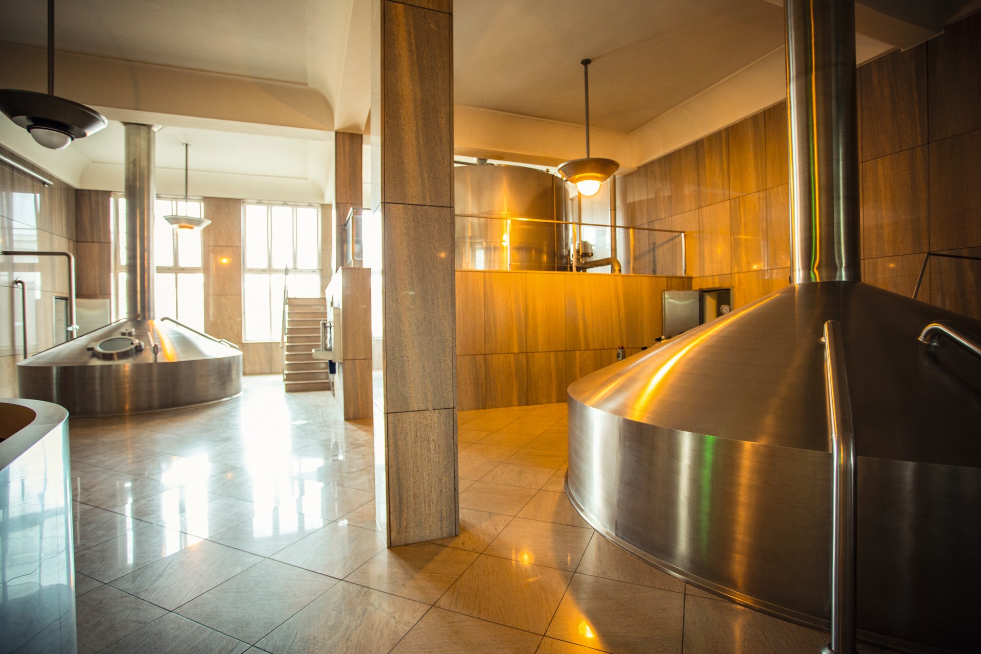 Innenansicht einer Brauerei mit geließtem Boden und Wänden und Sudkessel im Vordergrund