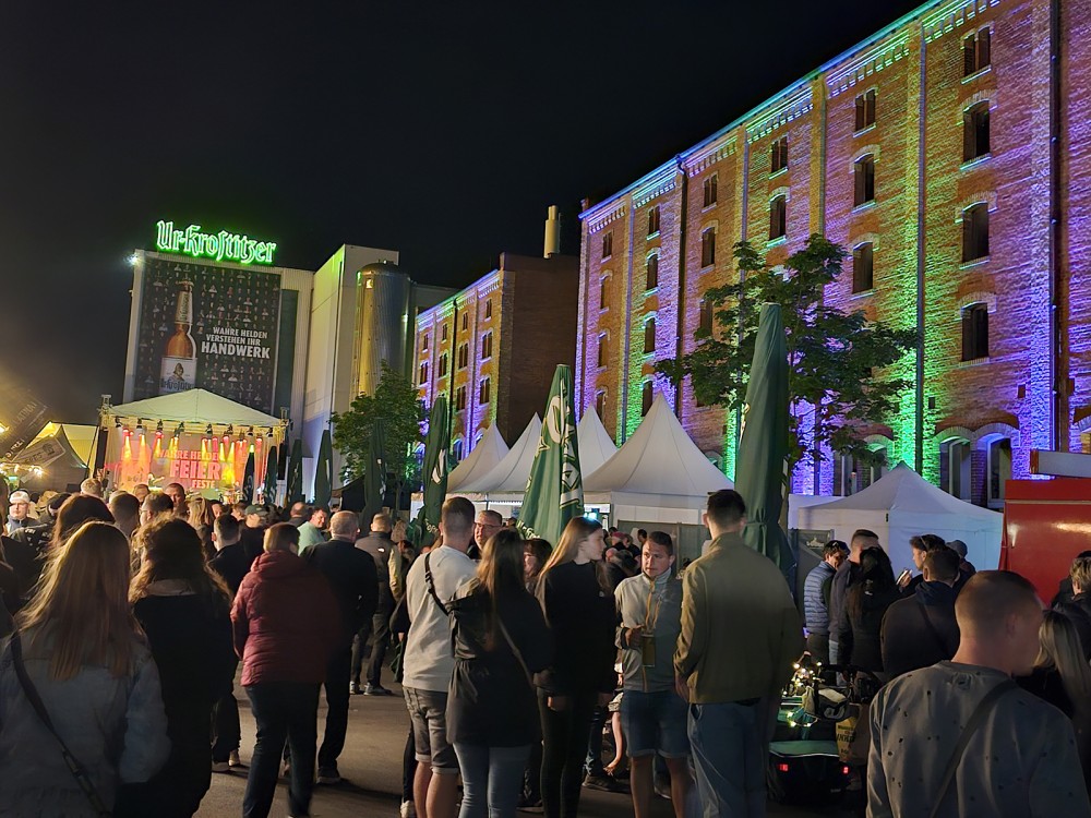 Viele Menschen stehen vor beleuchteten historischen Gebäuden auf einem Fest.