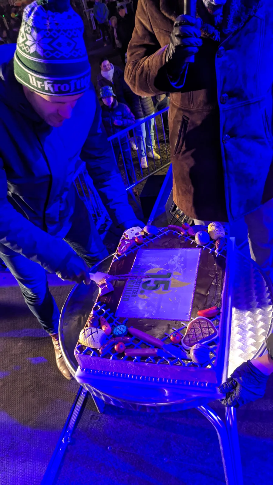 Ein Mann bedient ein beleuchtetes Tischklavier bei einem nächtlichen Event.