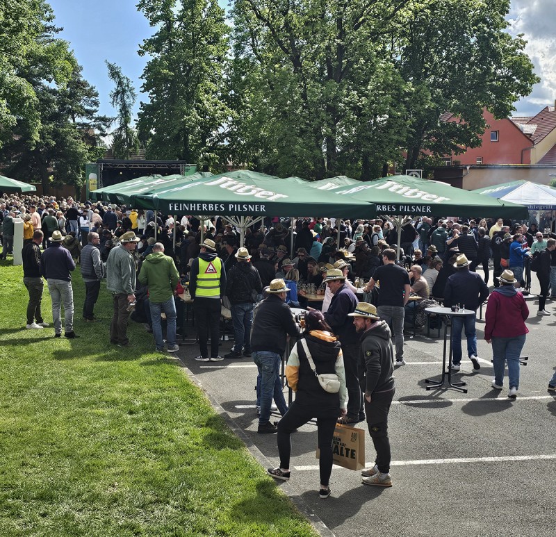 Ein Gruppe von Menschen feiert ein Fest auf dem Brauereihof unter Ur Krostitzer Schirmen.