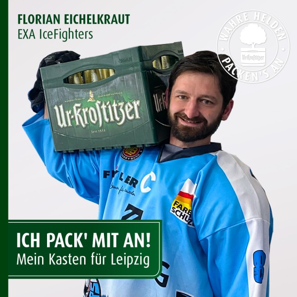 Ein Mann in einem blauen Sporttrikot trägt lächelnd einen Getränkekasten auf der Schulter.