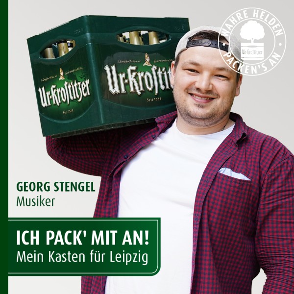 Ein lächelnder Mann trägt einen grünen Getränkekasten auf der Schulter.