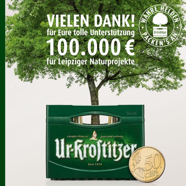Eine grüne Getränkekiste steht vor einem Baum, daneben liegt eine 50-Cent-Münze.
