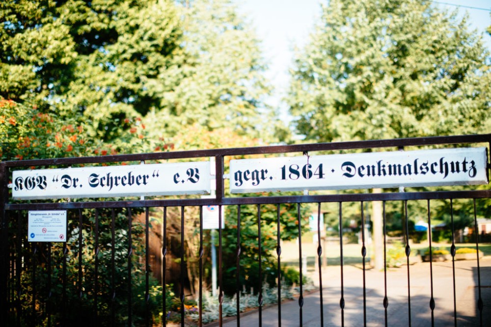 Schild am Eingangstor eines Gartens zeigt historische Aufschrift und Jahreszahlen.