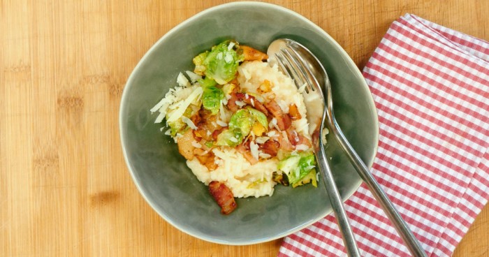 Ein Gericht mit Rösti, Speck und Rosenkohl in einer Schüssel auf einem Holztisch.